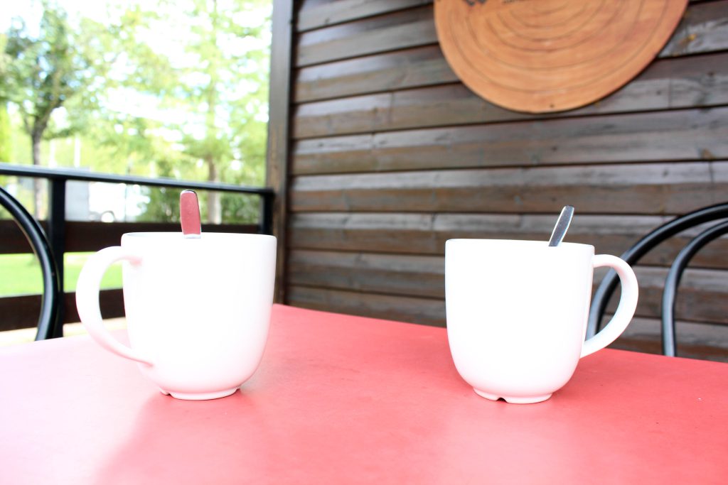 Dos tazas de café sobre la mesa del porche de una cabaña
